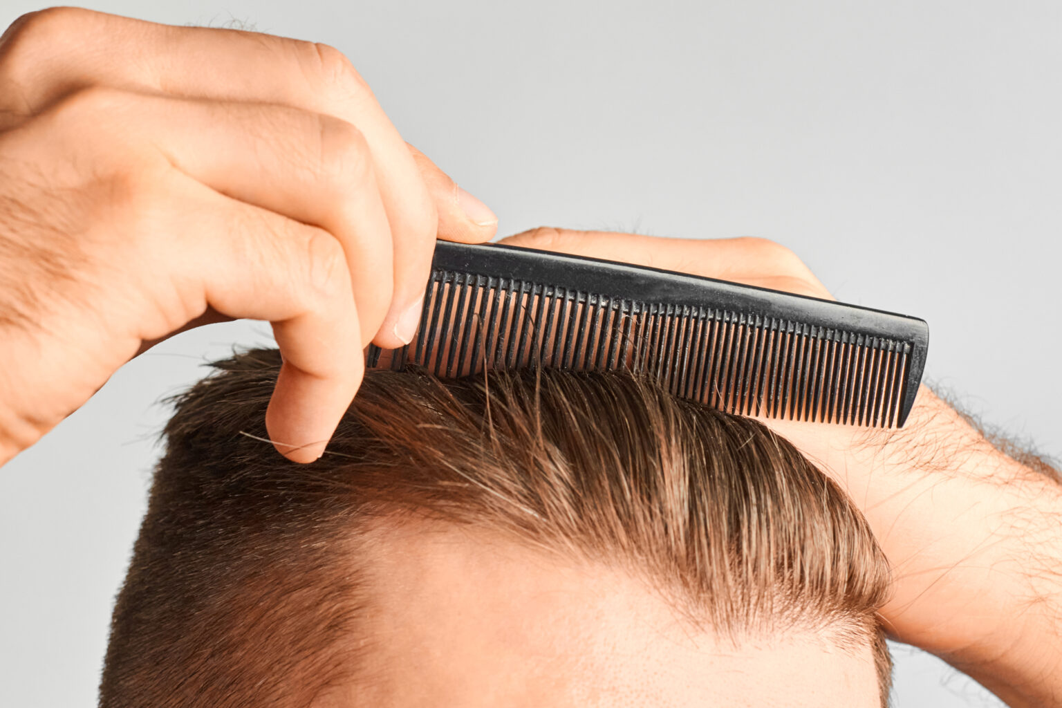 A man combing his hair with a comb
